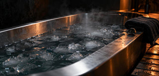 Baignoire en inox remplie d'eau glacée avec thermomètre posé sur le rebord, pour un bain froid de récupération sportive