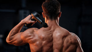 Sportif utilisant un pistolet de massage sur le trapèze supérieur, vue de dos, lumière cuivrée