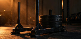 Traineau de musculation chargé de disques dans une salle sombre, station centrale de la préparation hyrox