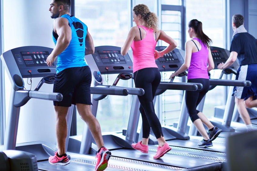 Course sur un tapis de course, un des équipements de sport pour s'entraîner à domicile