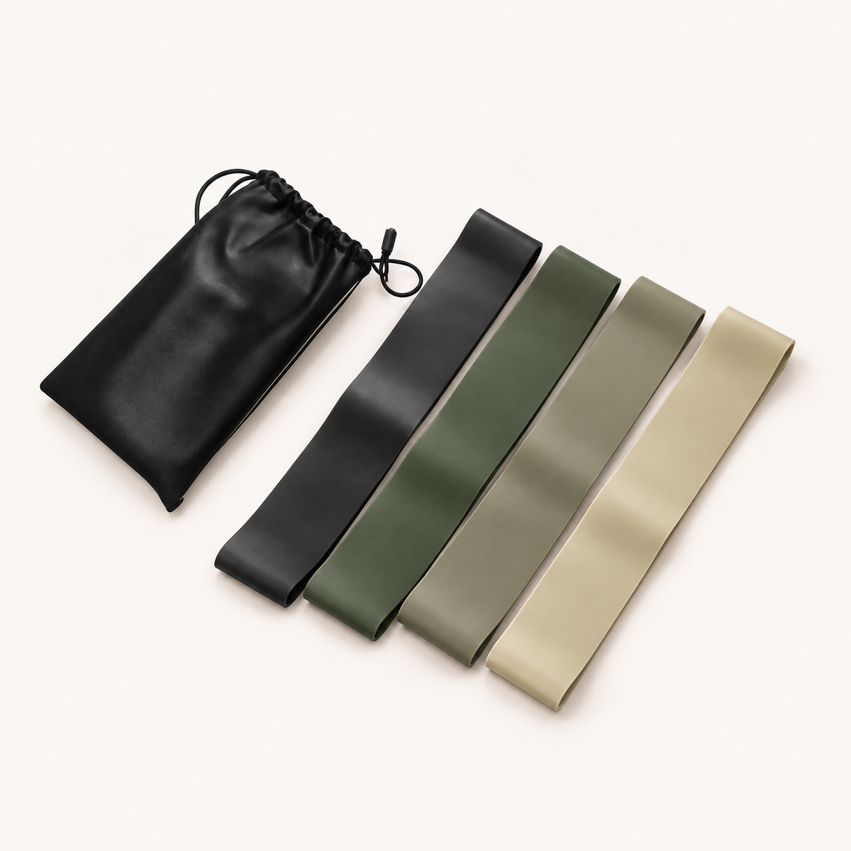 Set de 4 bandes élastiques de musculation, noire, vert foncé, vert sauge et beige, avec leur pochette, sur fond crème