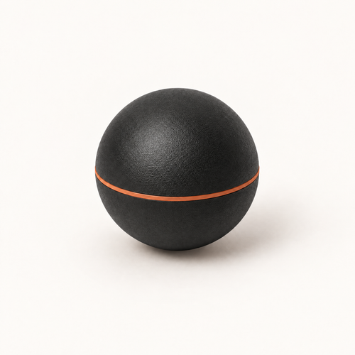 Balle de massage myofasciale Shapebox noire au liseré cuivre, sur fond crème