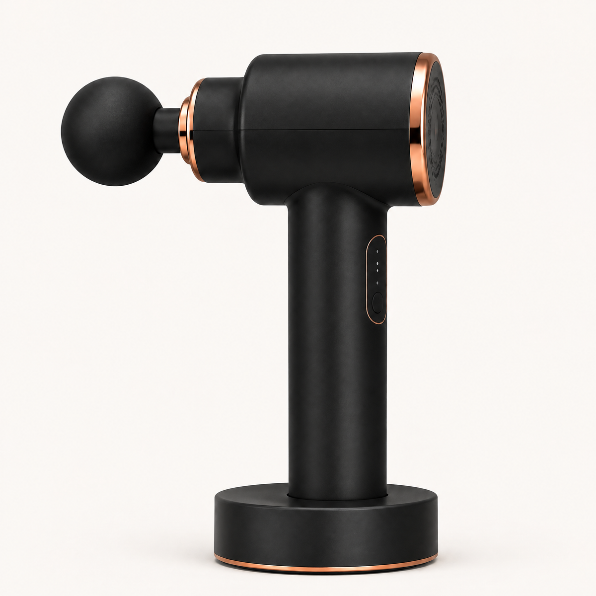 Pistolet de massage Shapebox Elite noir et cuivre sur sa base de charge, sur fond crème